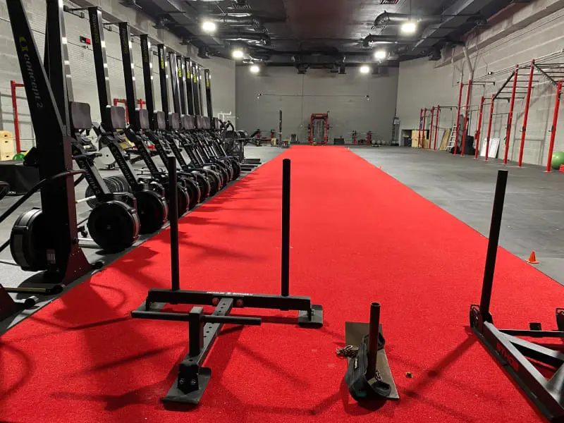 A gym with many different equipment on the floor.